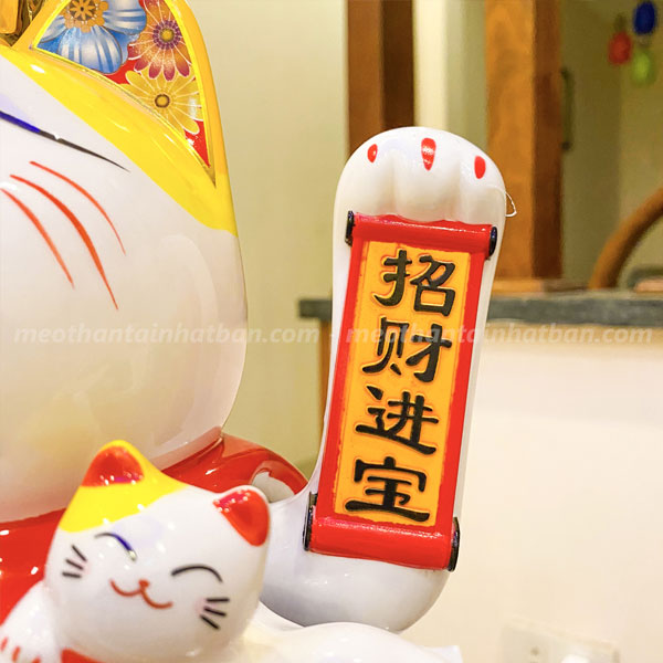Hình ảnh tay trái vẫy chữ “Chiêu Tài Tấn Bảo” mang ý nghĩa thu hút tài lộc