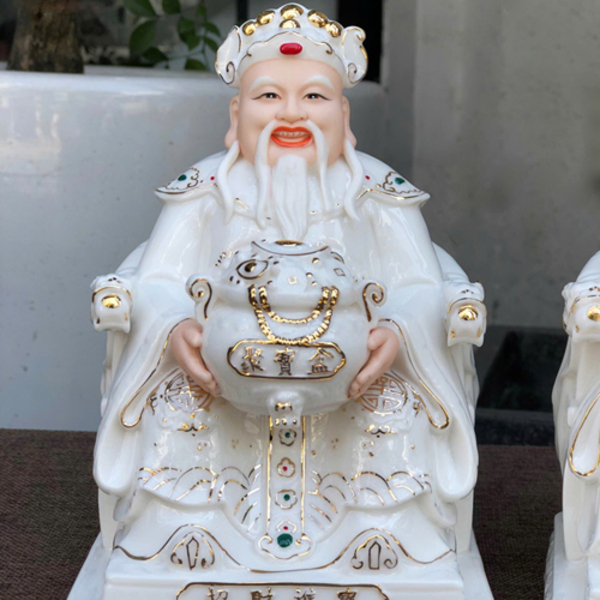 Thần Tài có gương mặt hiền từ, nét cười nhẹ nhàng, tay cầm hủ vàng lớn Thần Tài có gương mặt hiền từ, nét cười nhẹ nhàng, tay cầm hủ vàng lớn
